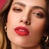 Frau mit voluminösen Lippen trägt einen roten Lippenstift