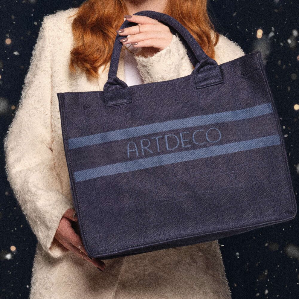Model hält große blaue Tote Bag