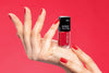 Es wird eine Hand gezeigt auf der ein roter Nagellack präsentiert wird