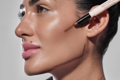 Model hält den ARTDECO Contour Stick mit cremiger Textur