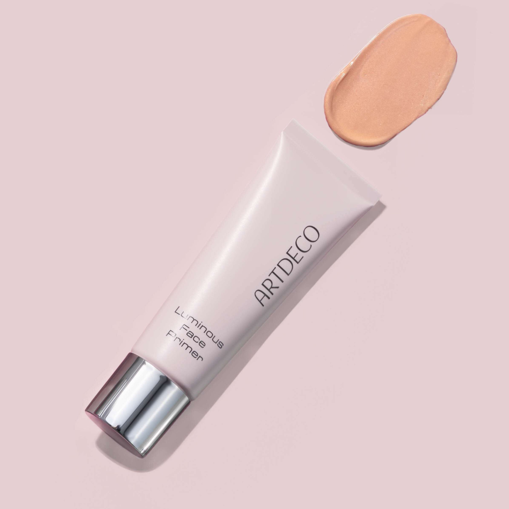 Luminous Face Primer liegt auf einem pinken Hintergrund mit einem Textur Swatch des Produktes
