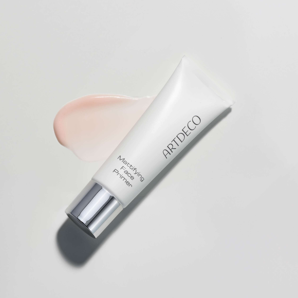 Mattifying Face Primer liegt auf einem grauenHintergrund mit einem Textur Swatch des Produktes