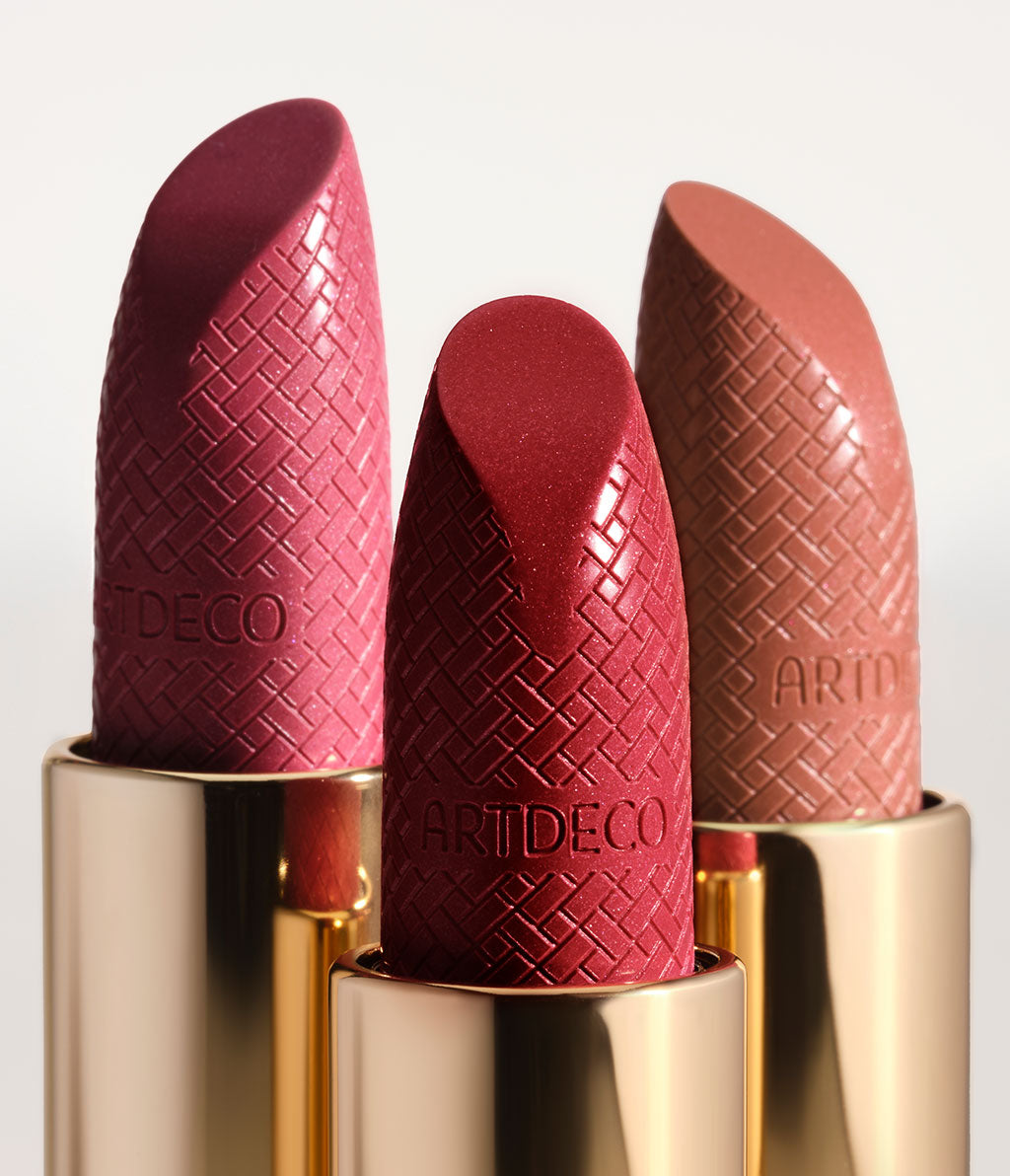 Drei geöffnete Iconic Lipsticks mit Fokus auf die Spitze des Lippenstiftes, in welche das Intrecciato-Design als auch das ARTDECO Logo eingeprägt sind.