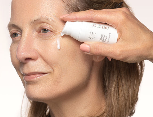Das Collagen Booster Serum für extra Vitamin C wird auf der Wange aufgetragen