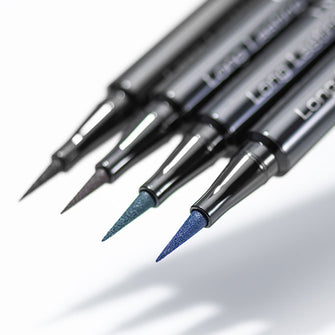 Vier Farben des Long Lasting Liquid Liner Intense schweben in der Luft und werfen Schatten.