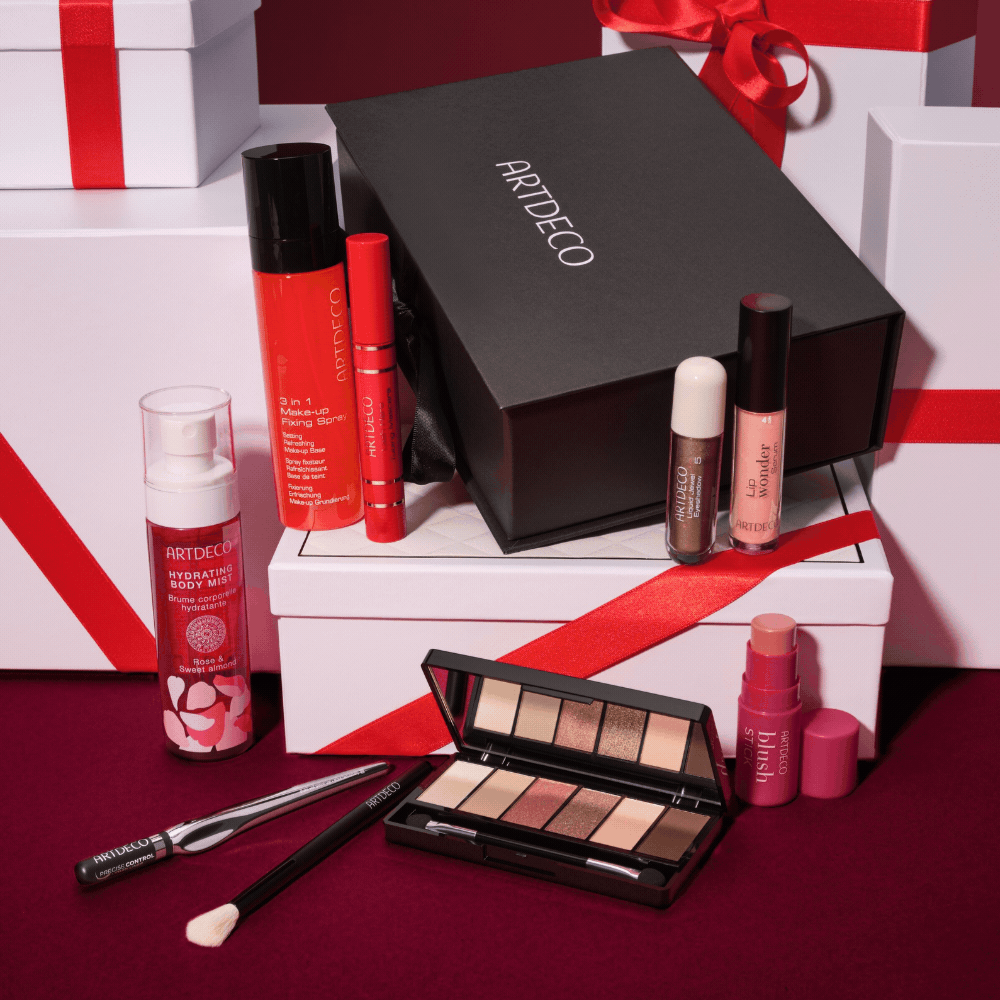 Wechselnde Moodbilder mit ARTDECO Make-up-Produkten des Online Exclusive Adventskalenders, darunter Lidschattenpalette, Blush Stick, Brow Lift Lamination und Lip Wonder Serum, festlich inszeniert mit Geschenkboxen und roten Schleifen.