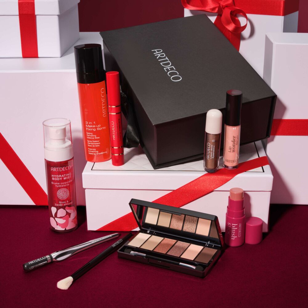 ARTDECO Online Exclusive Adventskalender mit ausgewählten Beauty-Produkten, darunter Lidschattenpalette, Blush Stick und weitere Make-up-Highlights, festlich inszeniert mit Geschenkboxen und roten Schleifen.